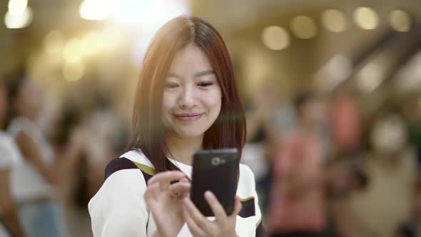 Beautiful Asian Female Using Smart Phone Tablet