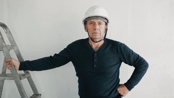 Portrait of handsome mature foreman in safety hard hat. Construction worker posing at camera.