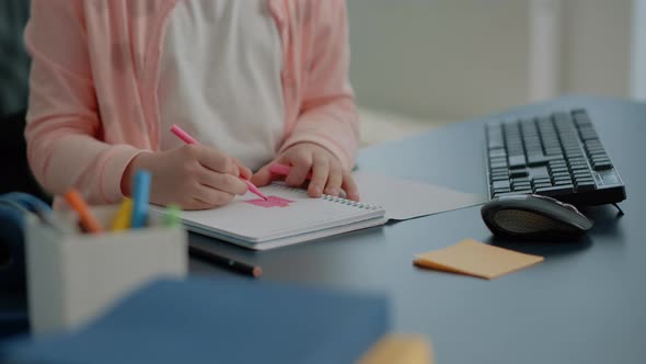 Close Up of Young Child Using Colorful Pencils on Notebook