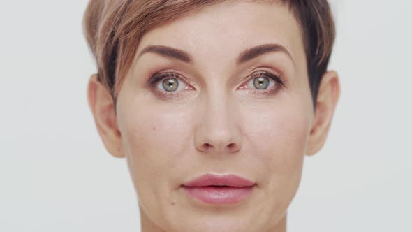 Close-up of middle aged mature woman over white background.