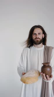 Jesus is Holding a Jug and Bread on a White Background