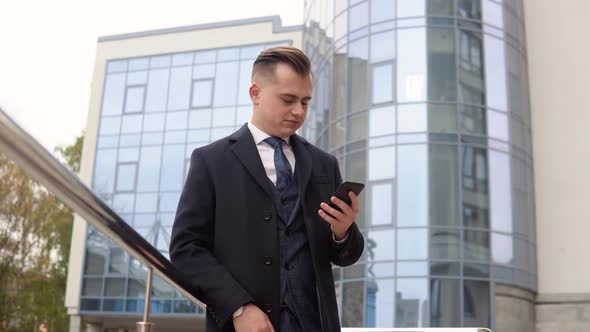 Handsome Startup Businessman Using Mobile Phone. Young Man Texting Messages, Cheating on His