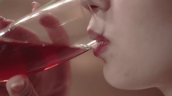 Young Beautiful Girl Drinks Wine in a Restaurant, Close-up