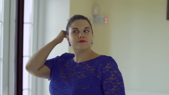 Fat Girl in a Blue Dress in Front of a Mirror