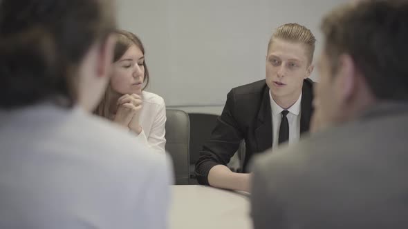 Portrait of Caucasian Man Sharing His Ideas on Business Meeting. Young Professional and Discussing