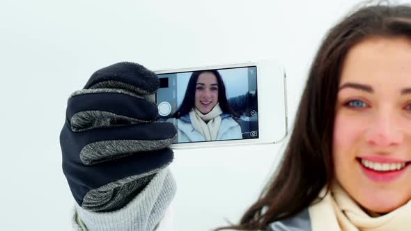 Smiling woman taking selfie on mobile phone