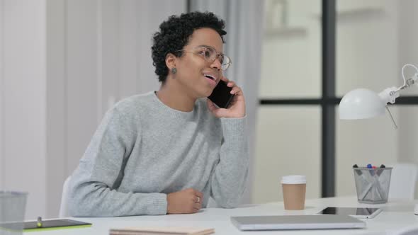 African Woman Talking on Smartphone at Work