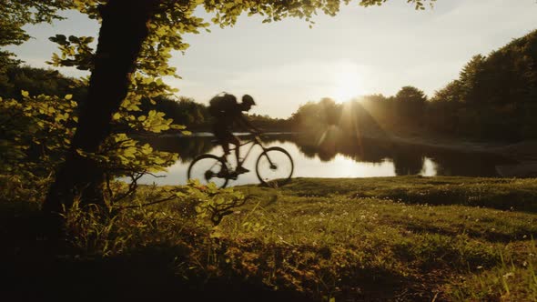 Boy with Mountain Bike By the Lake at Sunset