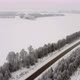 Aerial View Flying Over a Winter Track in the Middle of Snowcovered Trees on a Cloudy Day - VideoHive Item for Sale