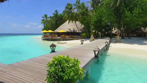 View of a tropical island dock pier over a beach.