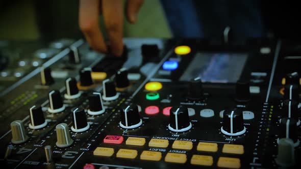 Nightclub DJ Adjusting Controls, Twisting Toggle on Professional Soundboard