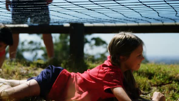 Kids crawling under the net during obstacle course training