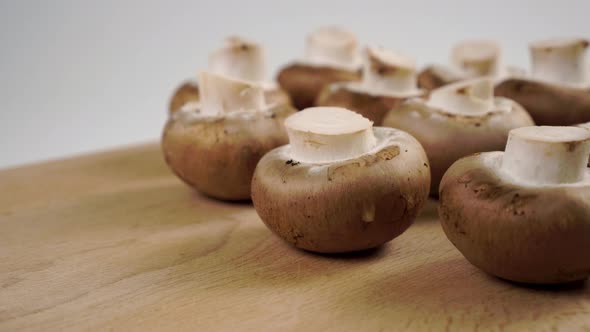 Raw brown mushrooms champignons on a wooden cutting board