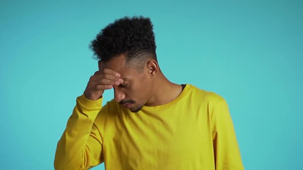 Young Student Man with Afro Hair Having Headache, Studio Portrait. Guy Putting Hands on Head