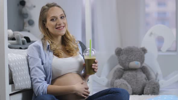 Portrait of Pregnant Woman Smiling with Smoothie