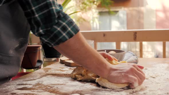 Male Hands Clapping and Sprinkling White Flour Over Dough on Kitchen