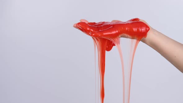 Red Slime Flowing Down From a Woman's Hand on a White Background