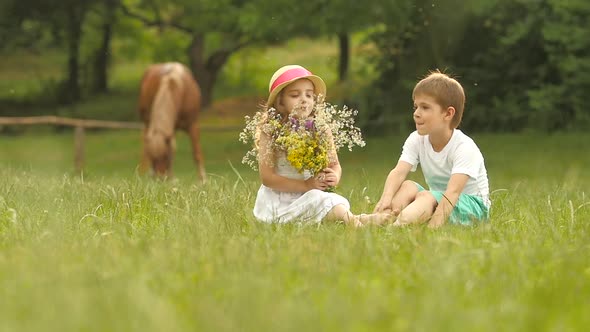 Little Boy Gives a Bouquet of Wild Flowers To a Girl. Slow Motion