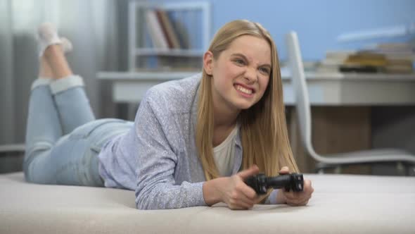 Emotional Teen Girl Playing Video Game at Leisure Time, Upset by Virtual Failure