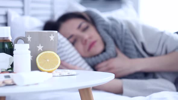 Sick Woman Lying on Bed with Flu at Grey Bedroom