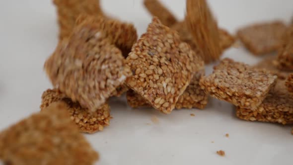 Best footage of dropping sticks of sesame seeds over a white plate