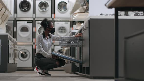 Black Woman is Buying Equipment for Home Kitchen African American Lady is Viewing Dishwasher