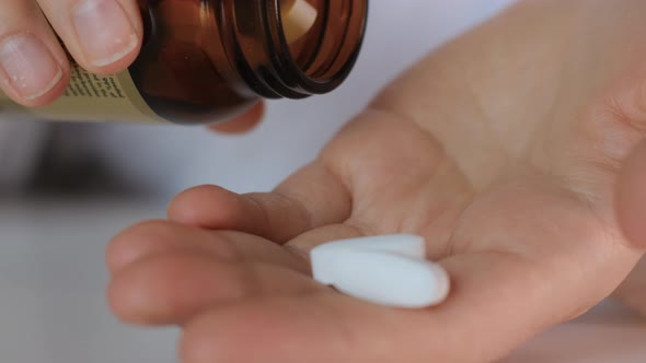 Close Up Hand Female Doctor Lays Out Put White Pills in Hand