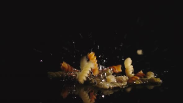 Colored Curly Pasta Falls Into Water