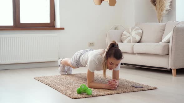 Young Healthy Caucasian Woman Workout at Home Does Plank Exercise on Mat