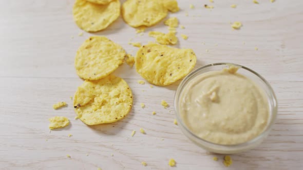 Video of crisps and cheese dip on a wooden surface