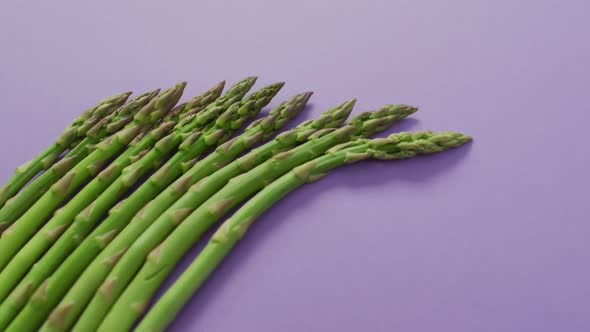Video of fresh asparagus with copy space over lilac background