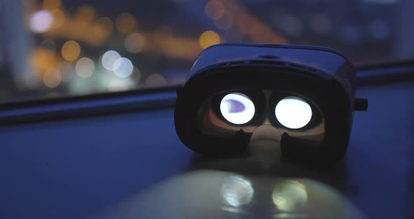 Virtual reality headset playing video over city view at night