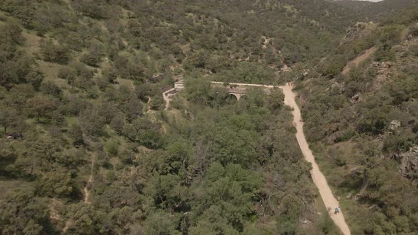 Drone shot of Spanish countryside, hike near a bridge and waterfall