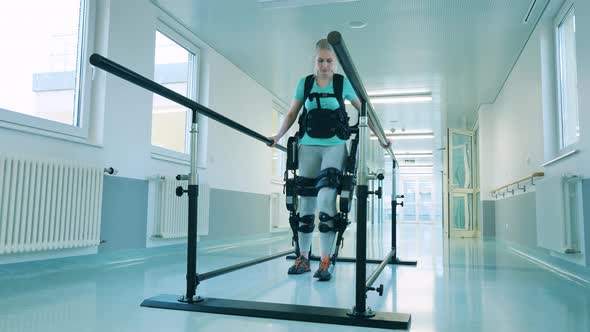 Young Woman with Disability is Learning to Walk in the Exoskeleton