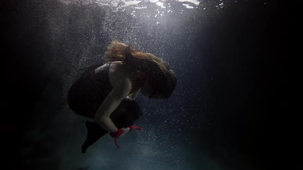Brunette Woman Is Diving in Depth of Pool or Ocean in Dark Water Slow Motion