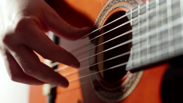 Closeup of Male Musicians and Playing the Strings of an Acoustic Guitar