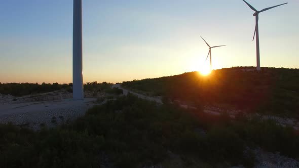 Aerial view from bottom to top of white wind turbines