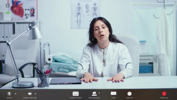 Woman Doctor Talking To Camera and Giving Online Medical Consultation