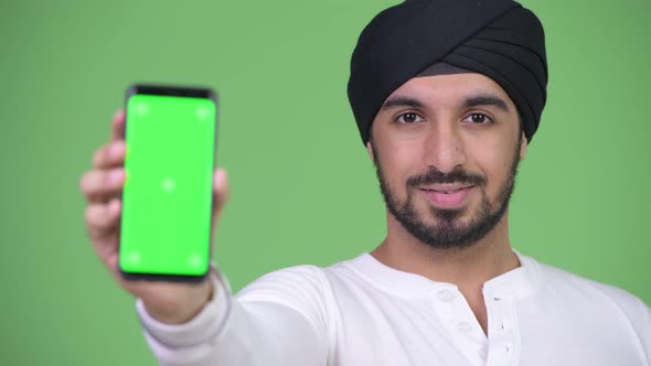 Young Happy Bearded Indian Man Showing Phone