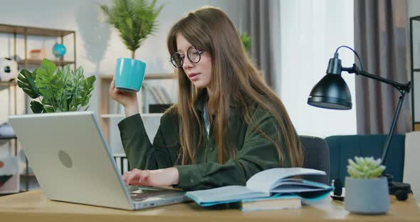 Female Student in Glasses Sitting at Home and Working Over University Home Task on Computer