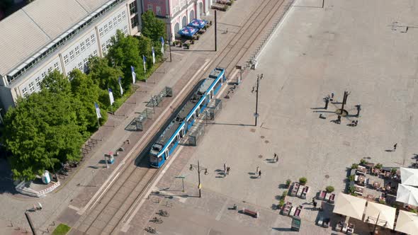 Descending and Tilt Up Footage of Tram Leaving Tram Stop at Neue Markt Square