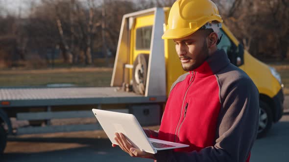 Engineer Wearing Helmet Holding A Laptop And Working Checking His Planned Work
