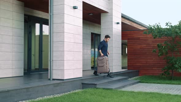 Business Man Going Outside Luxury Hotel with Suitcase. Casual Man Going Out Home