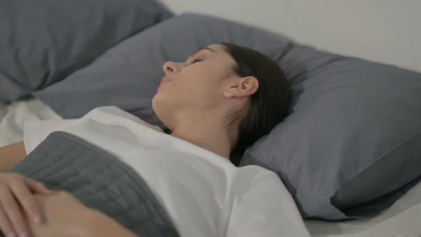 Hispanic Woman Feeling Uncomfortable while Sleeping in Bed