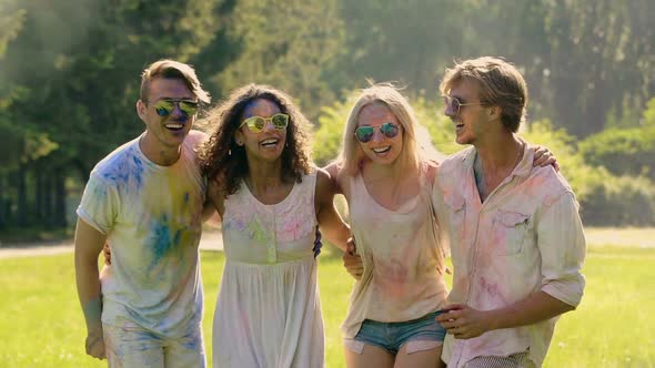 Four Happy Friends Jumping Covered in Colorful Powder, Traditional Holi Festival