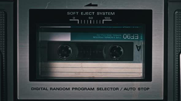 Audio Cassette Tape Rotates in Deck of an Old Tape Recorder