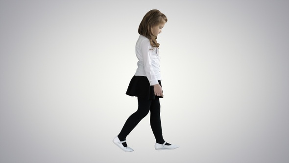 Little girl with long hair walking and looking down on