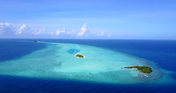 Wide angle fly over tourism shot of a sunshine white sandy paradise beach and aqua turquoise water