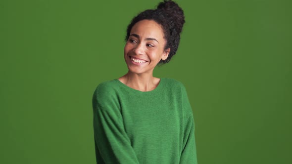 Smiling African woman in green shirt posing in the studio