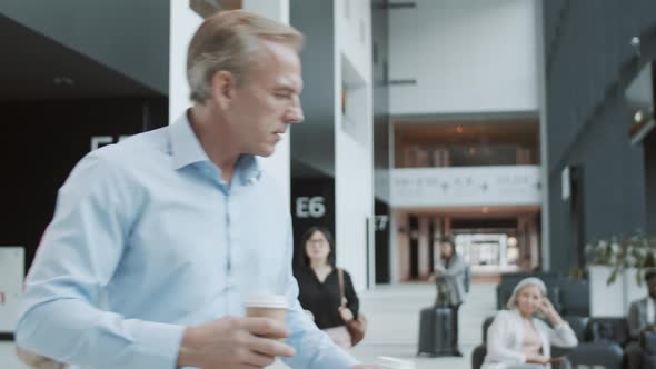 Caucasian Man Getting Coffee for Wife while Waiting for Flight at Airport